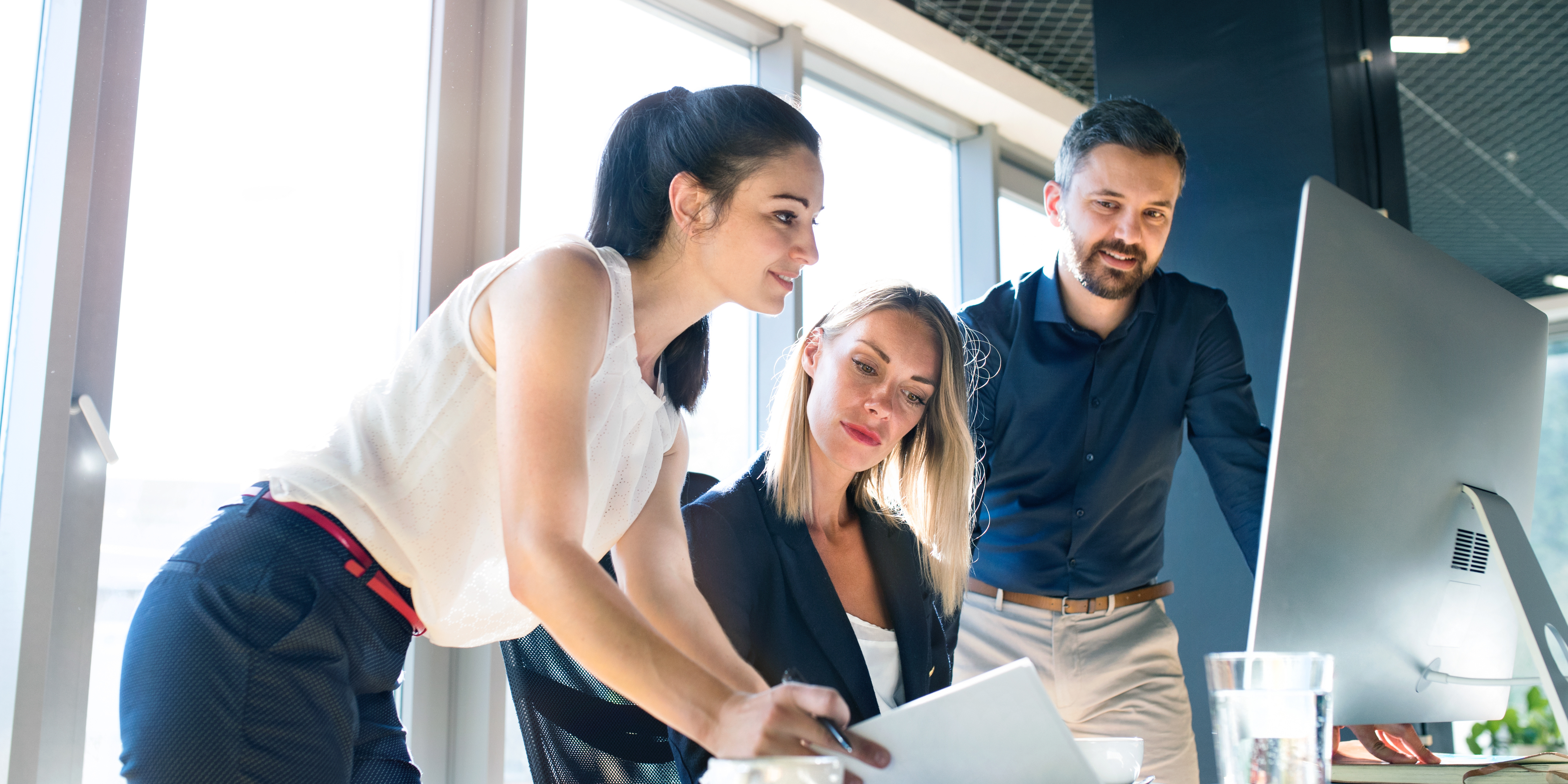 Drie mensen bekijken op een computerscherm HaloITSM-oplossingen voor servicedesk in de Benelux.